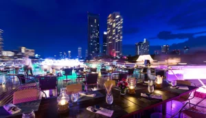 Cruzeiro noturno Grand Pearl navegando pelo rio Chao Phraya com templos iluminados ao fundo.