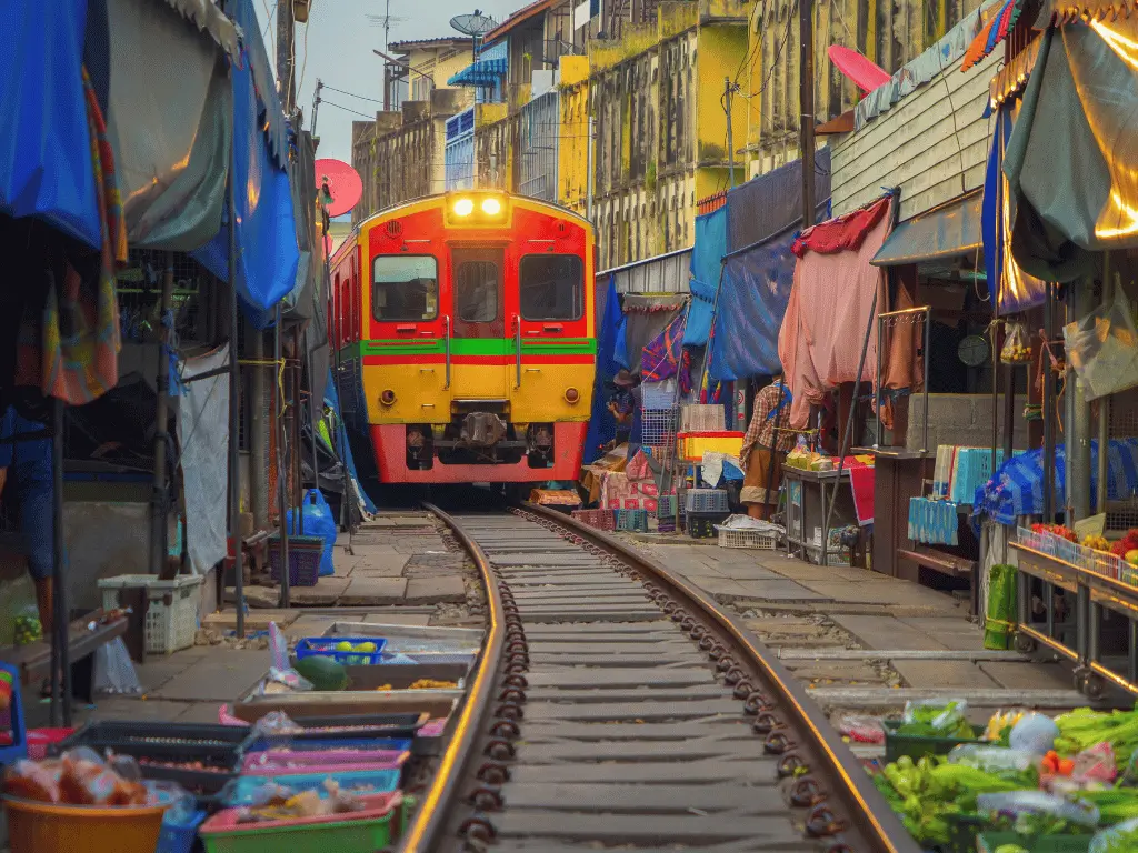 Mercado do Trem em Bangkok: vagões passando a centímetros das barracas em um dos cenários mais curiosos da Tailândia.