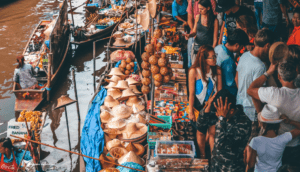 Mercado flutuante na Tailândia com barcos repletos de frutas e comerciantes locais.