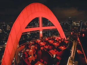 Restaurante Red Sky com mesas ao ar livre e skyline de Bangkok.