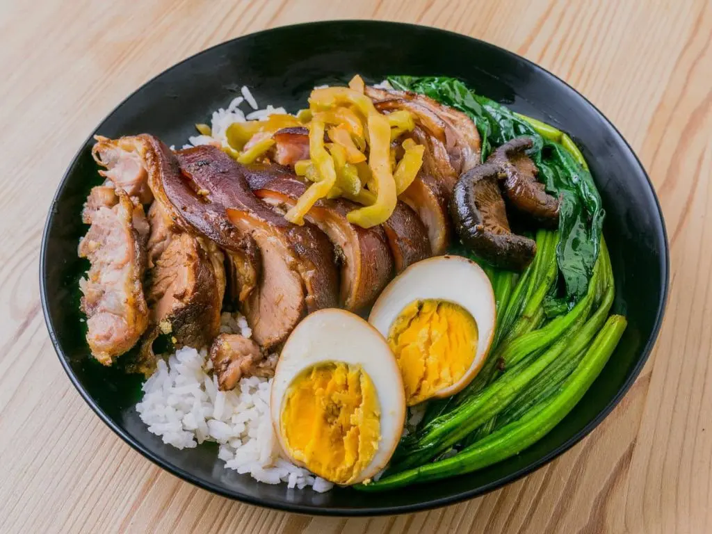 Comer de boa na Tailândia: prato de Khao Kha Moo, pernil de porco macio com arroz e ovo cozido.